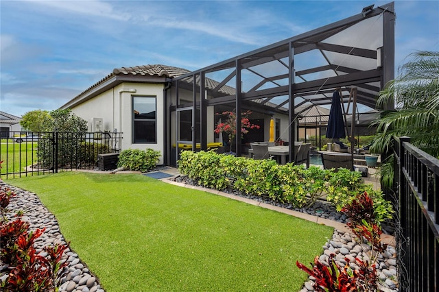 rear view of property with glass enclosure, a yard, and a patio