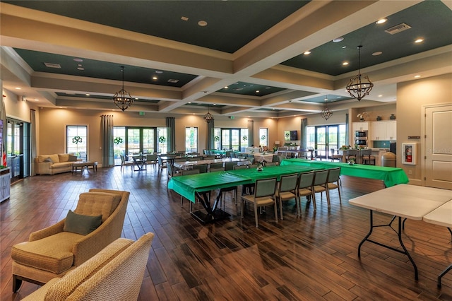 recreation room with plenty of natural light, hardwood / wood-style floors, beam ceiling, and a chandelier