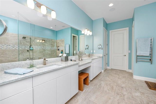 bathroom with a tile shower and vanity