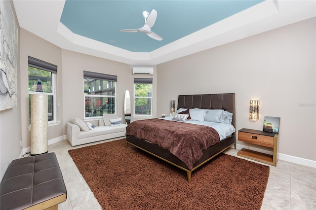 bedroom with ceiling fan, light tile patterned floors, a raised ceiling, and a wall mounted air conditioner