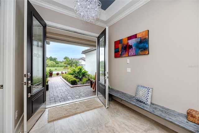 entrance foyer with light tile patterned flooring, a chandelier, and ornamental molding