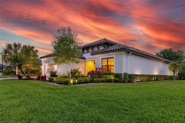 property exterior at dusk with a yard