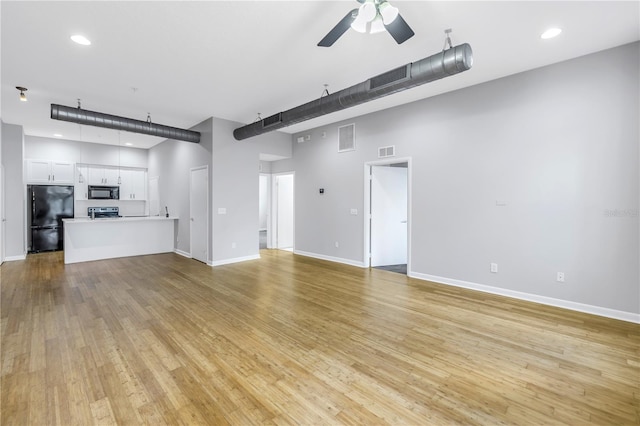 unfurnished living room featuring ceiling fan and light hardwood / wood-style flooring