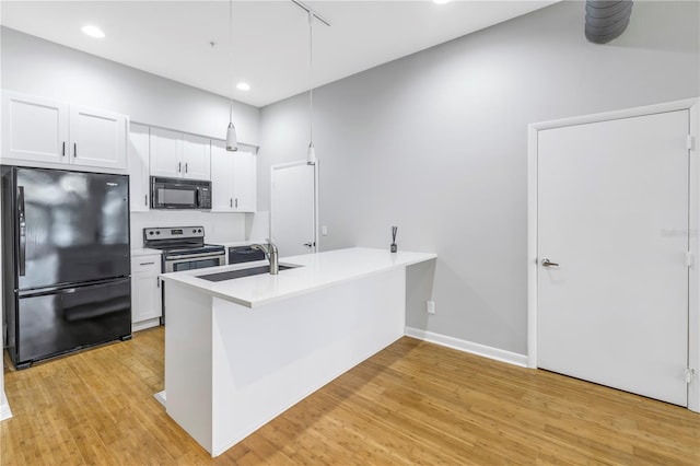 kitchen featuring kitchen peninsula, sink, white cabinets, light hardwood / wood-style flooring, and black appliances