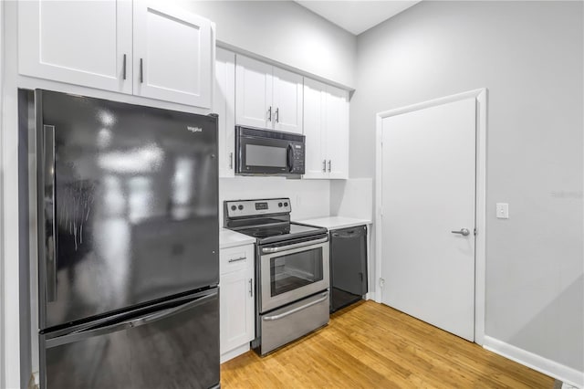 kitchen with light hardwood / wood-style floors, white cabinets, and black appliances