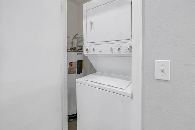 washroom featuring tile floors, electric water heater, and stacked washing maching and dryer