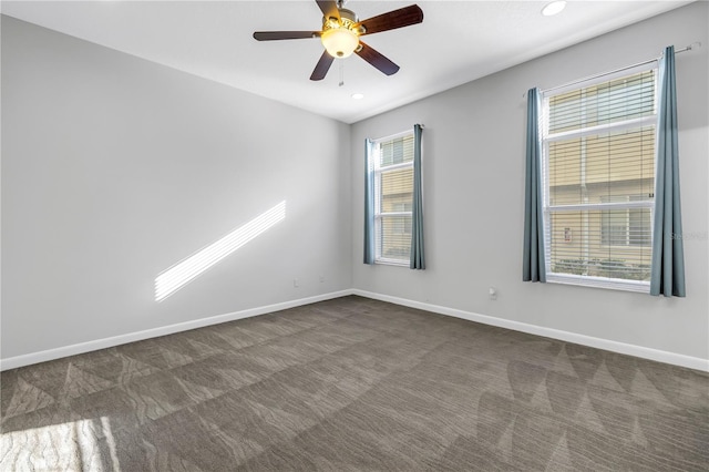 unfurnished room with ceiling fan and dark colored carpet