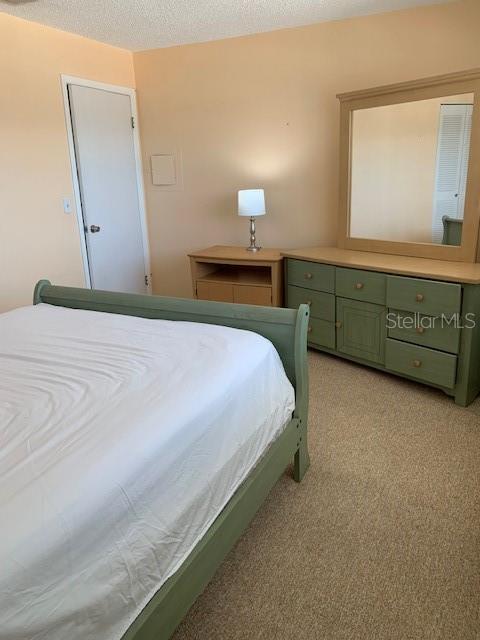 bedroom with light carpet and a textured ceiling