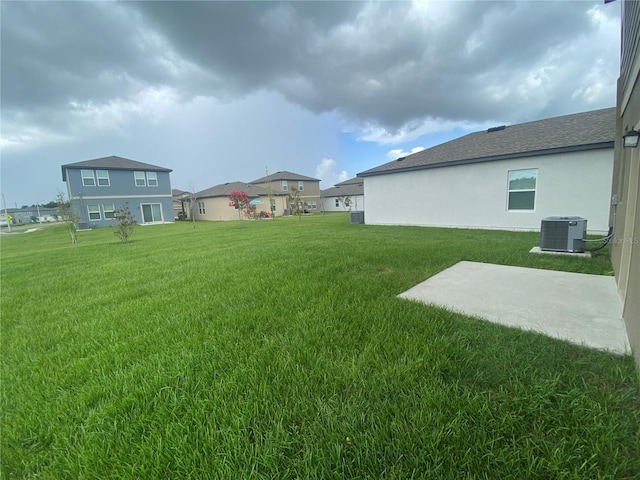 view of yard with central AC and a patio area