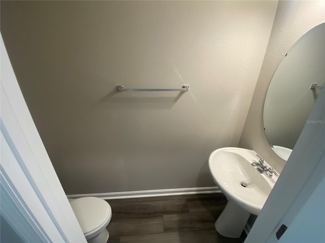 bathroom featuring hardwood / wood-style flooring and toilet