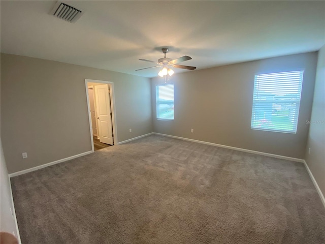 carpeted spare room with ceiling fan