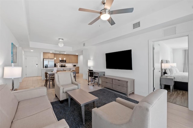 living room with ceiling fan and light hardwood / wood-style flooring