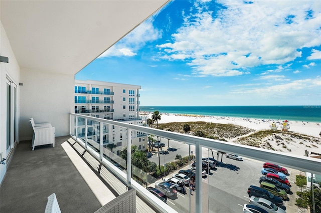 balcony with a water view and a view of the beach