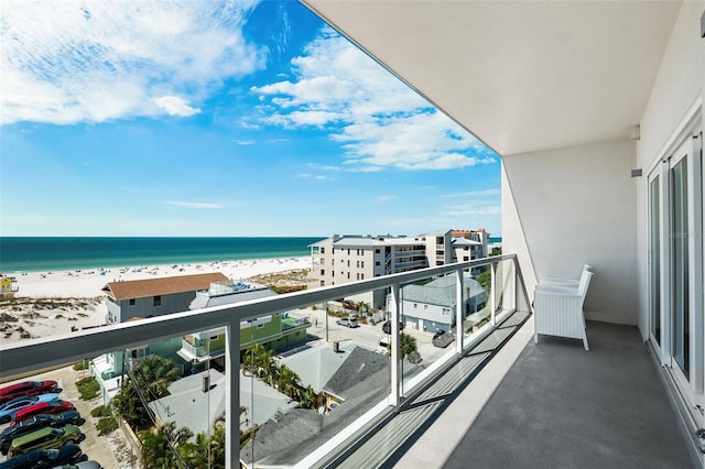 balcony featuring a water view and a beach view