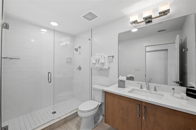 bathroom featuring toilet, tile patterned floors, vanity, and an enclosed shower