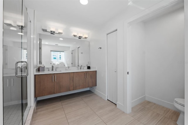 bathroom with walk in shower, tile patterned floors, dual vanity, and toilet