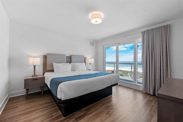 bedroom featuring a water view and hardwood / wood-style floors