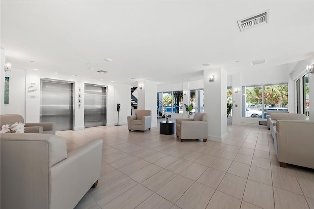 living room with light tile patterned flooring, elevator, and a wealth of natural light