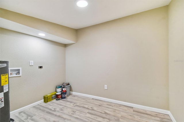 washroom featuring hookup for a washing machine, water heater, light hardwood / wood-style floors, and hookup for an electric dryer