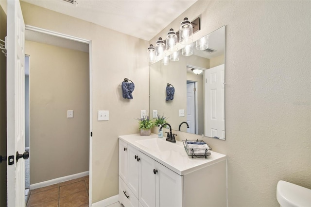 bathroom featuring vanity, tile patterned flooring, and toilet