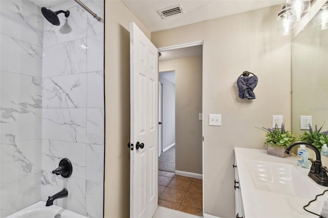 bathroom featuring tile patterned floors, tiled shower / bath, and vanity