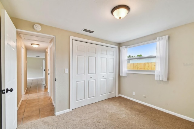 unfurnished bedroom with light carpet and a closet