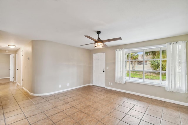 tiled spare room featuring ceiling fan