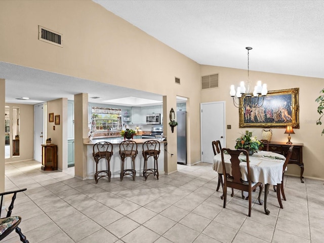 dining space with high vaulted ceiling, a textured ceiling, a notable chandelier, and light tile floors