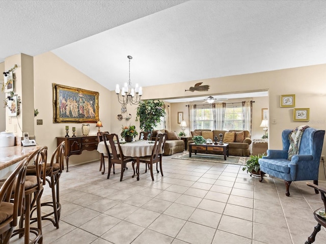 dining space featuring light tile floors, lofted ceiling, a textured ceiling, and ceiling fan with notable chandelier