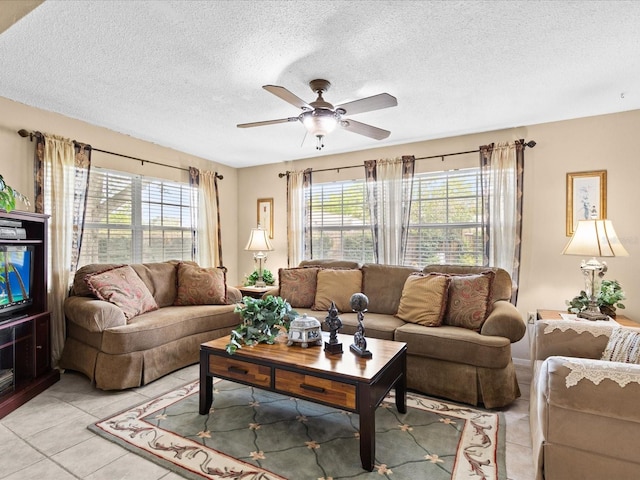 living room featuring a textured ceiling, ceiling fan, and light tile floors