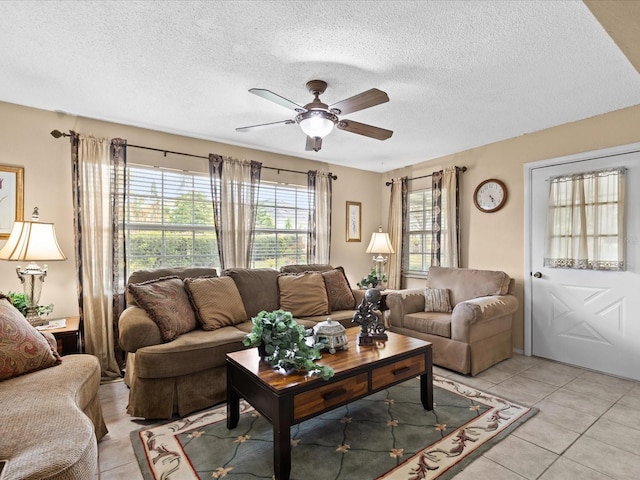 tiled living room featuring a textured ceiling, a healthy amount of sunlight, and ceiling fan