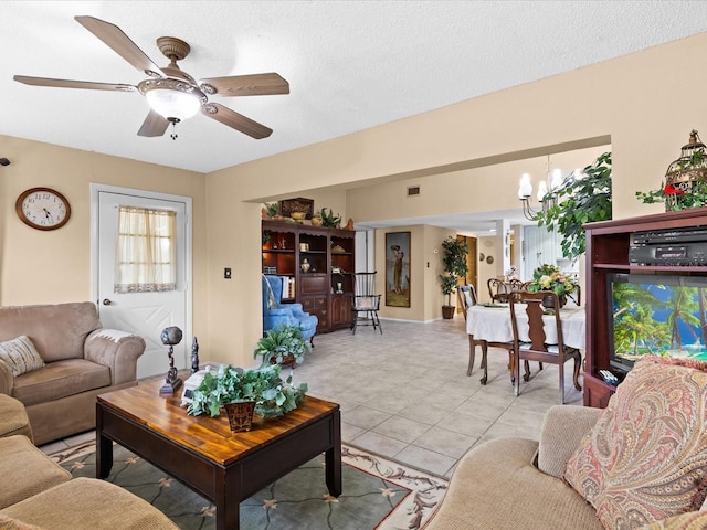 living room featuring a textured ceiling, ceiling fan with notable chandelier, and light tile floors