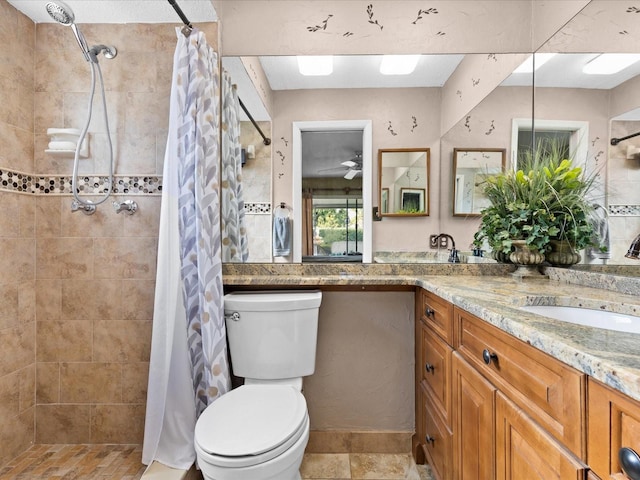 bathroom featuring walk in shower, toilet, ceiling fan, tile flooring, and vanity