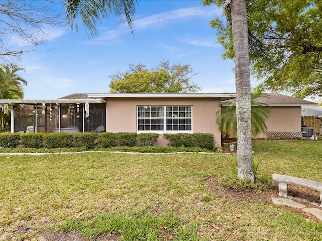 single story home featuring central AC, a front lawn, and a sunroom