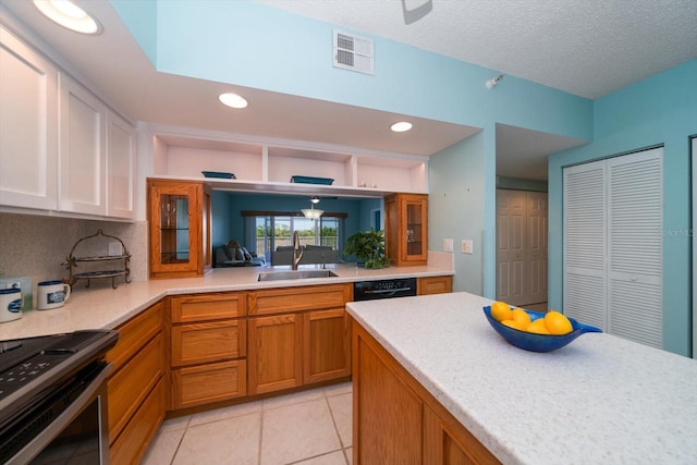 kitchen with light tile floors, electric stove, dishwasher, a textured ceiling, and sink