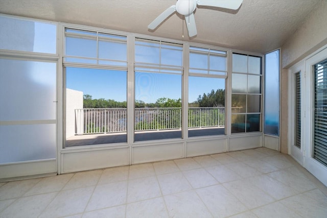 unfurnished sunroom featuring ceiling fan