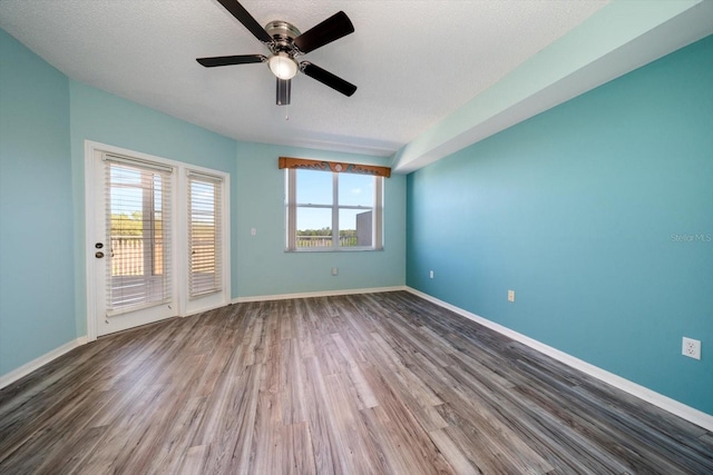 spare room with dark hardwood / wood-style floors, a textured ceiling, and ceiling fan