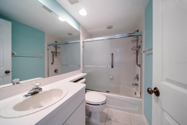 full bathroom featuring tile floors, toilet, combined bath / shower with glass door, and vanity with extensive cabinet space