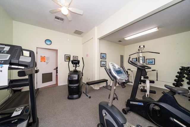 workout room with ceiling fan and dark colored carpet