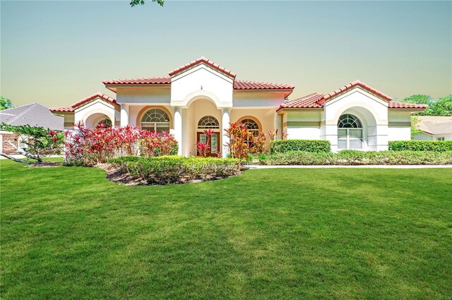 mediterranean / spanish-style home with a lawn