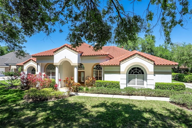 mediterranean / spanish home featuring a front lawn