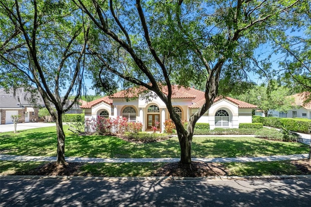 mediterranean / spanish home featuring french doors and a front yard