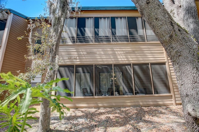 rear view of house featuring a balcony and a sunroom