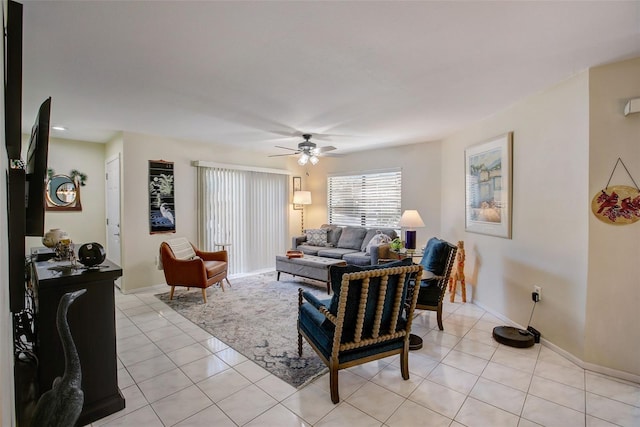 living room with baseboards, a ceiling fan, and light tile patterned flooring