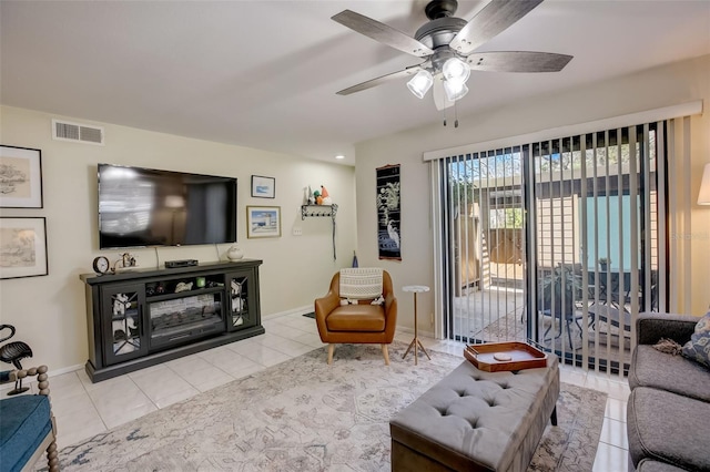 tiled living area featuring a ceiling fan, visible vents, and baseboards