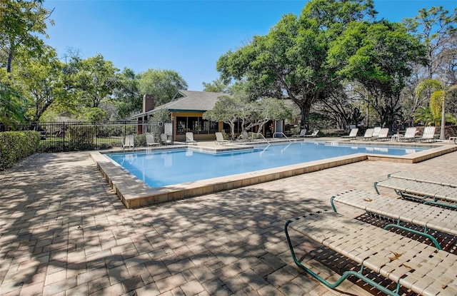 pool with a patio and fence