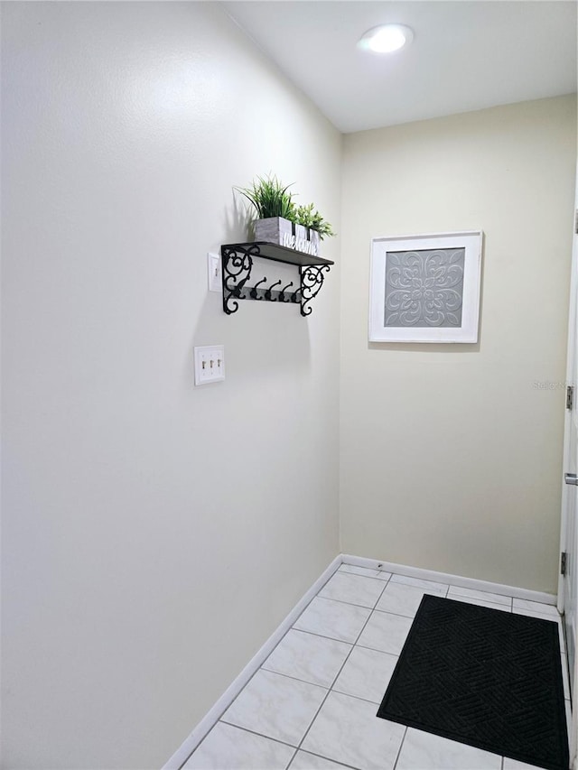 interior space featuring baseboards and light tile patterned flooring