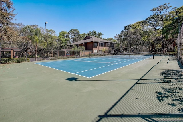 view of tennis court featuring fence