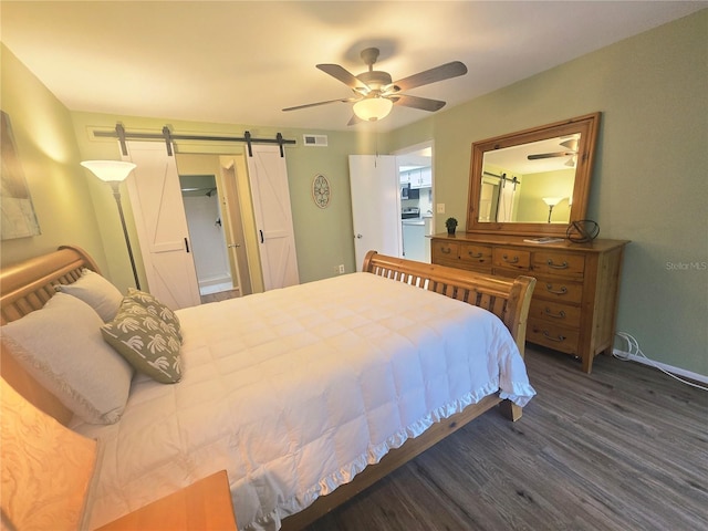103 Cypress Pond Rd Unit 103, Palm Harbor, FL 34683 - bedroom with wood finished floors, a barn door, baseboards, visible vents, and a ceiling fan