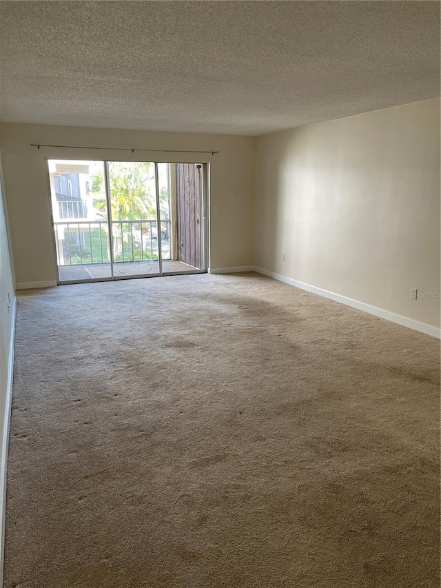 carpeted empty room featuring a textured ceiling